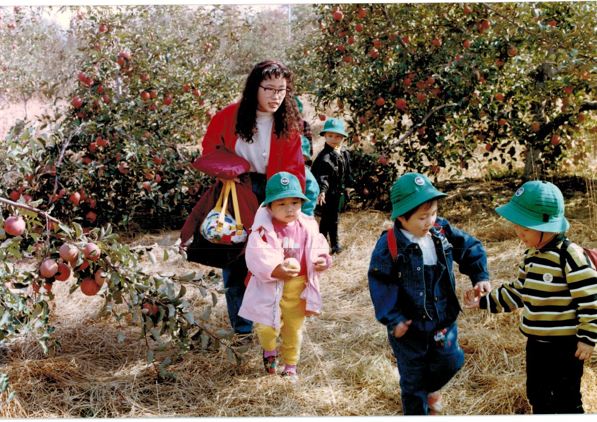 Gina Kim with kindergarten students on an apple orchard field trip